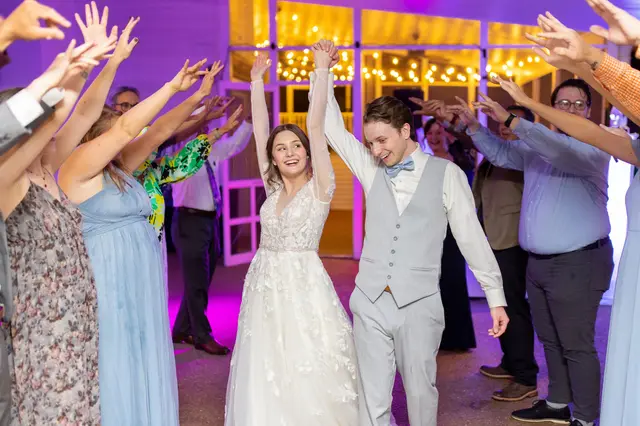 Couple dancing with their guests under purple lights