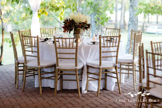 Gold chairs around a round table on the brick patio