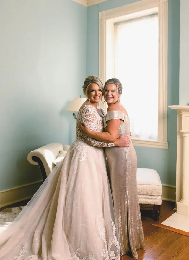 Bride hugging her mother in the blue parlor