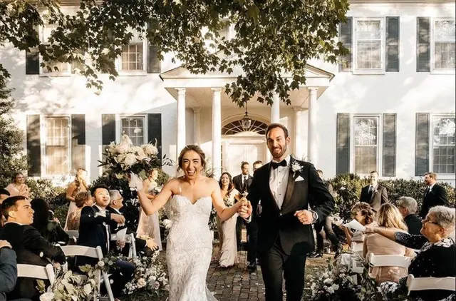 Newlyweds walking back up the aisle in front of the mansion