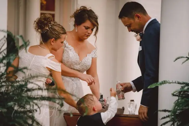 Bride and groom pouring a sand ceremony with a young boy