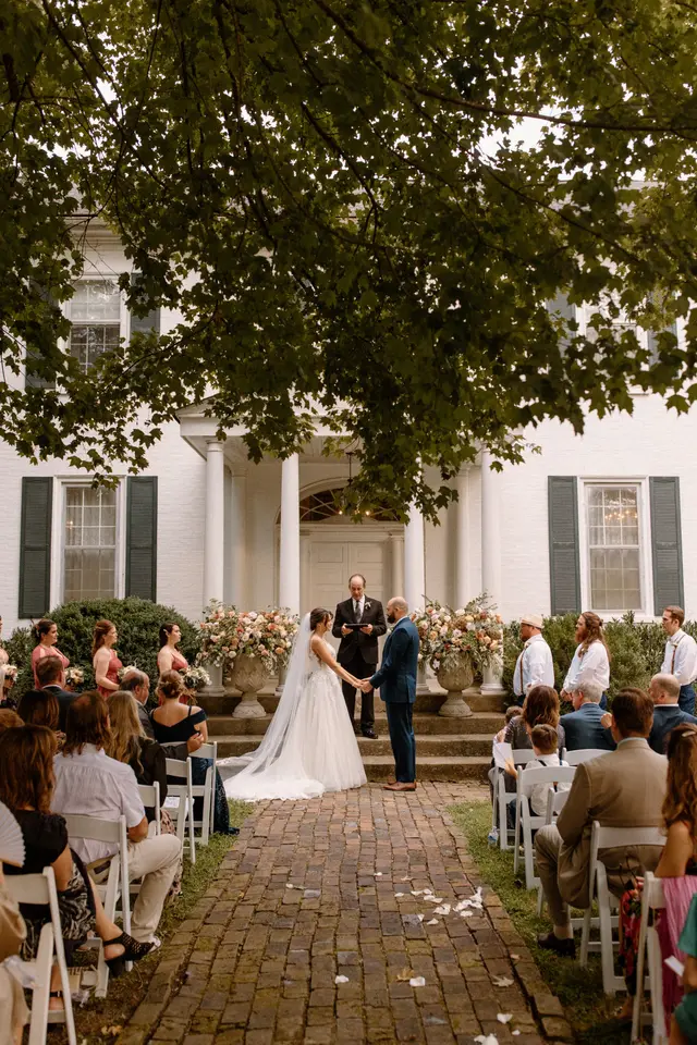 Ceremony on the front steps of the mansion, seen down the brick aisle