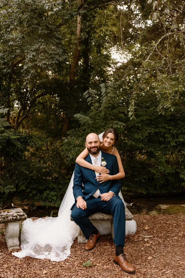Couple seated on a stone bench in the woods