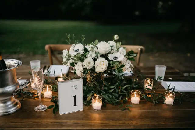 Head table with candles, white roses and a table number