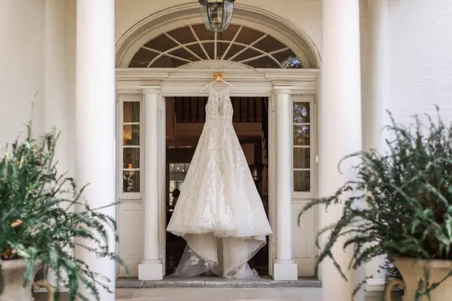 Wedding gown hanging in the front doorway between the columns