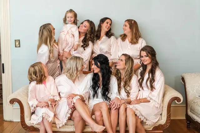 Bridesmaids and flower girls in white robes on a settee