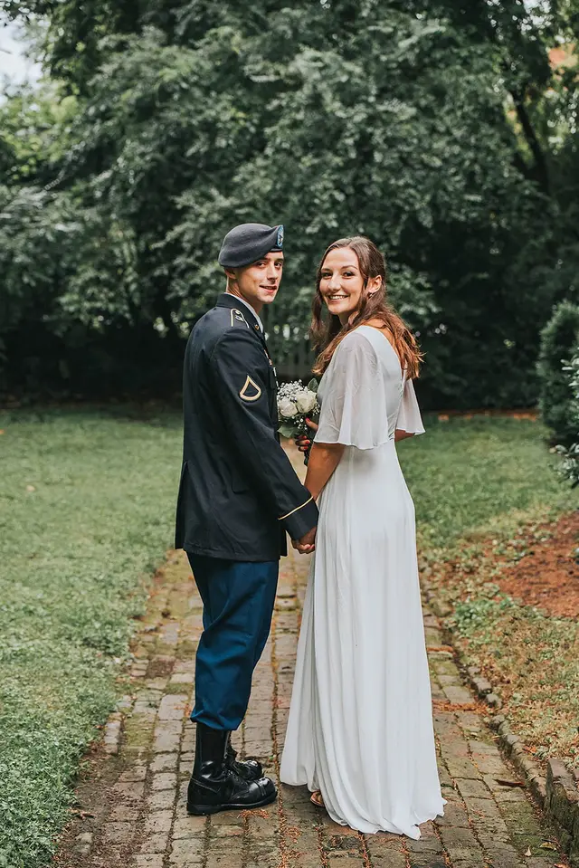Soldier in dress uniform with his bride on the brick path