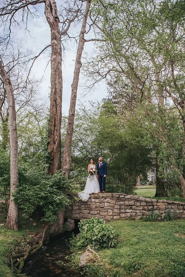 Couple on a stone bridge over the creek in the woods