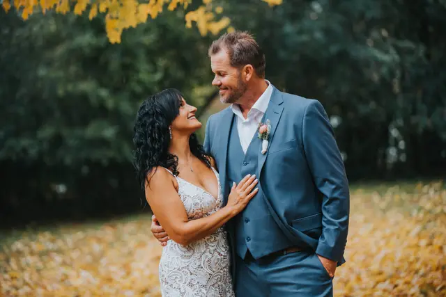 Couple laughing together among fallen yellow leaves