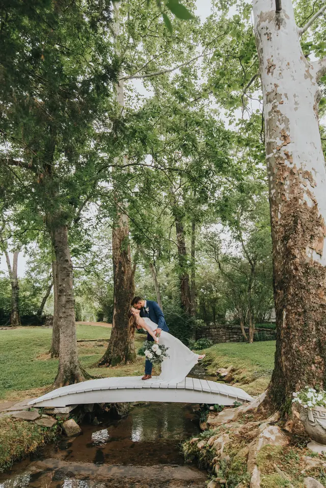 Groom dipping the bride for a kiss on the footbridge